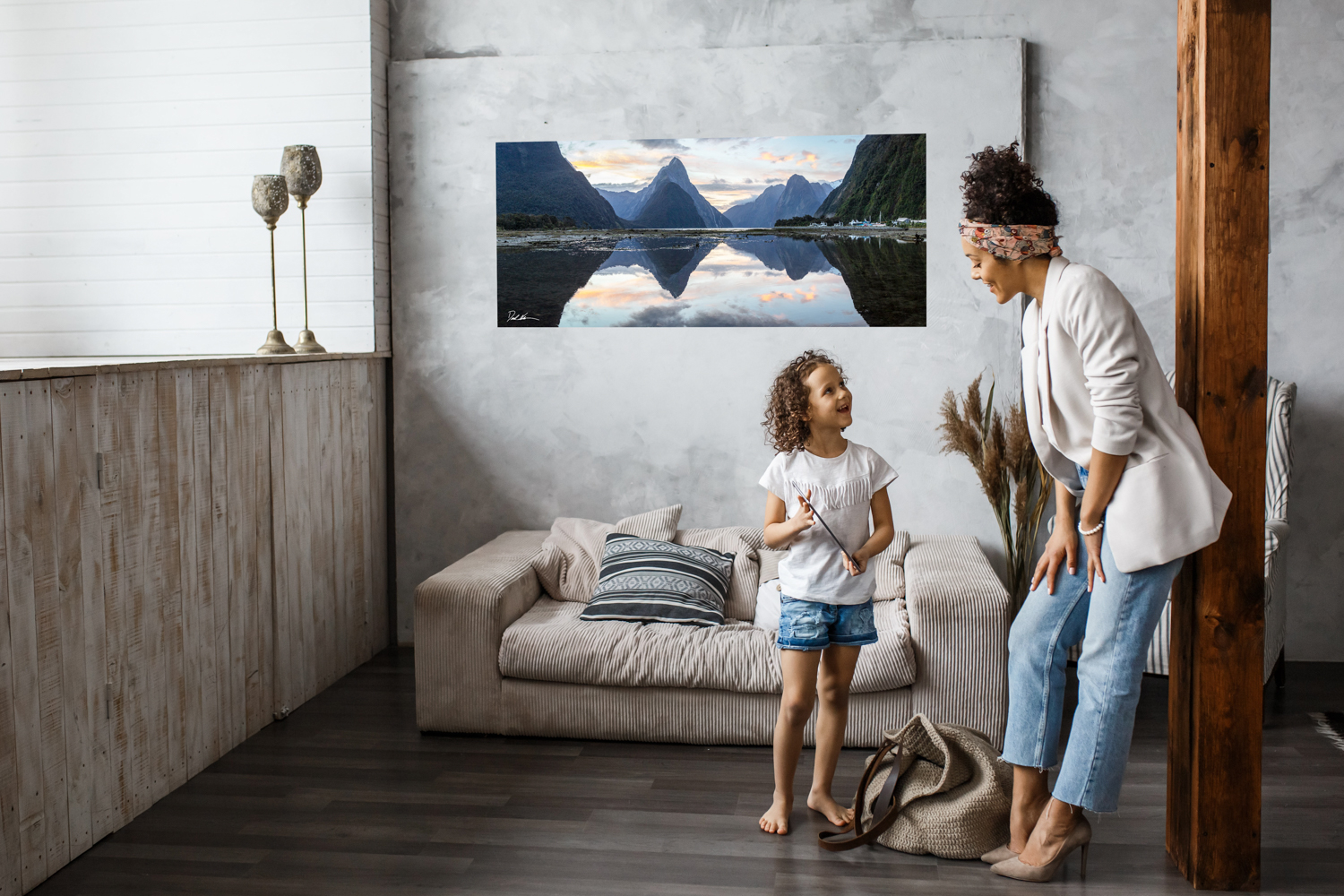 beautiful mountain photo hung in modern home with happy relaxed mother and daughter smiling