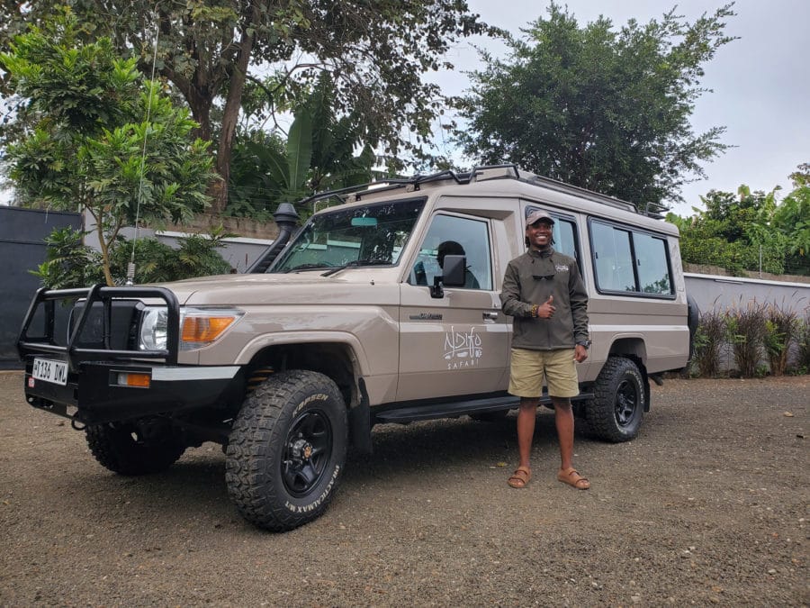 Photo of Steven Gowi standing next to his Ndifo safari vehicle