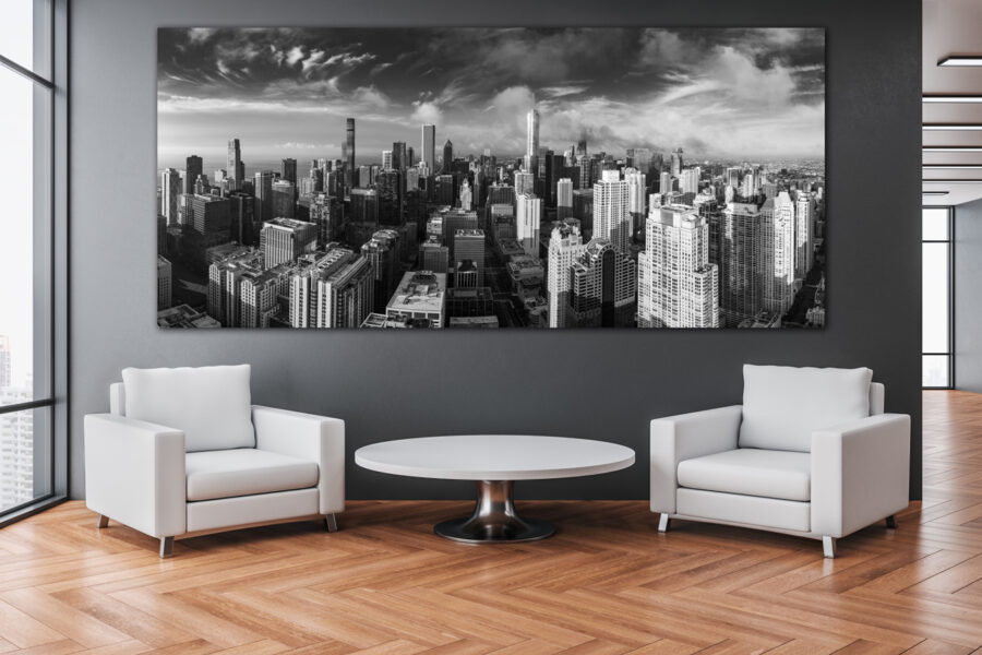 Large panoramic black and white luxury fine art print of Chicago displayed above two chairs in an office building