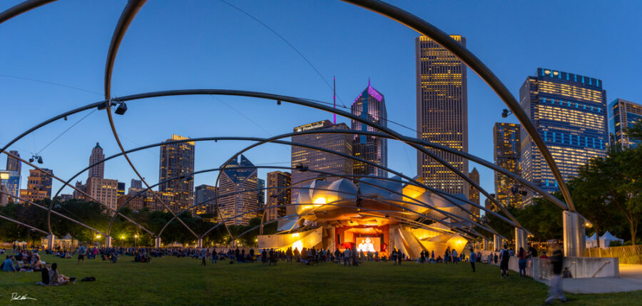 panoramic image of Jay Pritzker Pavilion in Millennium Park Chicago during Blues Fest at dusk. 