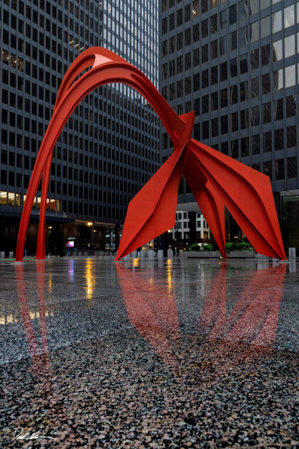 image of Alexander Calder's flamingo statue in Chicago with a reflection on the ground of the statue