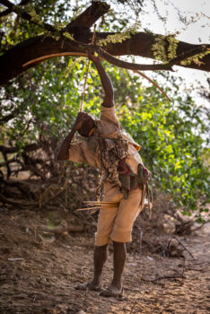 hadzabe tribe member taking aim with his bow and arrow