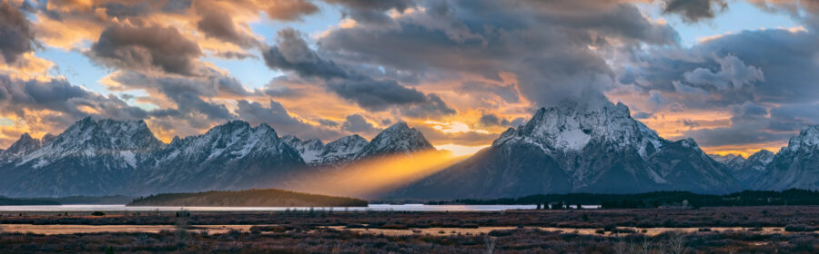 Image of the Grand Teton National Park at sunset with a beautiful light beam splitting the mountains 