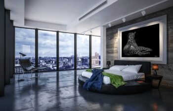 large fine art print of a leopard displayed above a be in the bedroom of a modern luxury condo