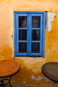 image of a blue window against a deep orange wall in Santorini