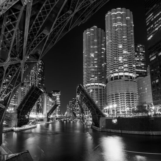 black and white image of the Chicago river with all the bridges up at night
