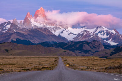 The sun kissed mountains of Argentina's Patagonia in the early morning looking down a long road