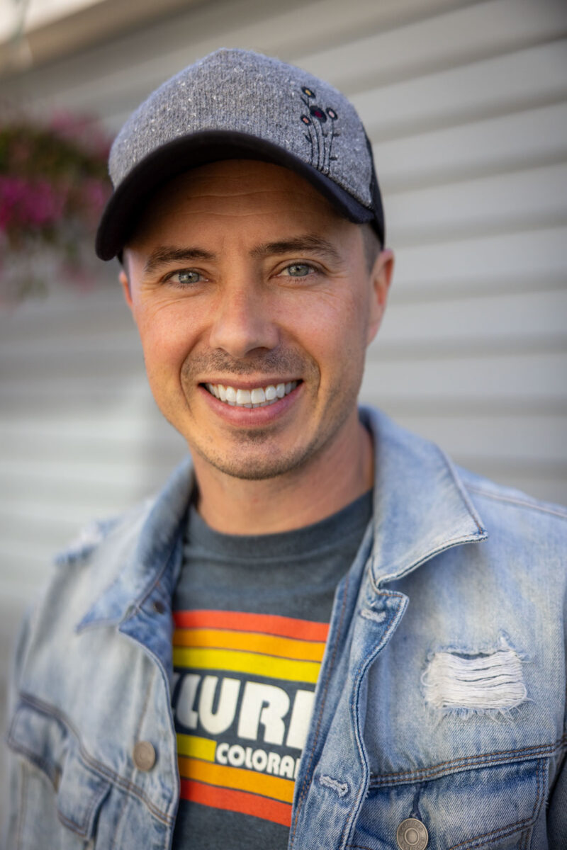 photograph of photographer Derek Nielsen wearing a hat with a jean jacket