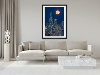 large framed fine art print of a moon rising over chicago displayed in a modern luxury home