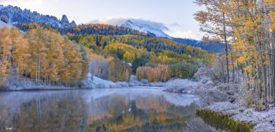 Large panoramic image of a dusting of snow over fall colors in the mountains of colorado