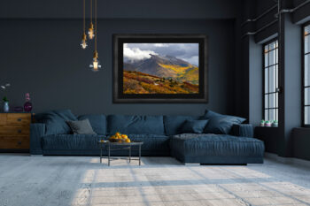 Large framed fine art print of the mountains around Telluride Colorado during fall displayed above a couch in a modern home