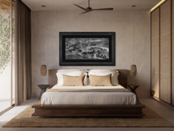 Large framed fine art print of wildebeest crossing the Mara River in Tanzania displayed in the bed room of a luxury home