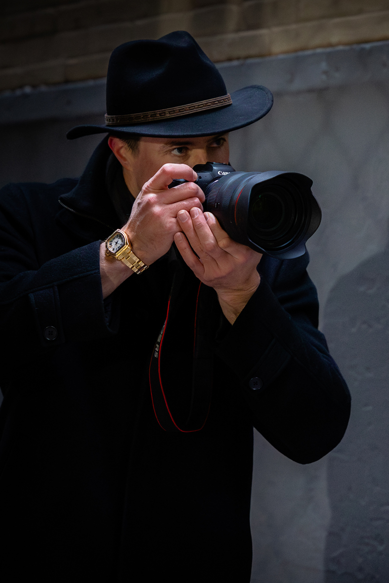 Photographer Derek Nielsen shooting photos wearing a gold Cartier watch