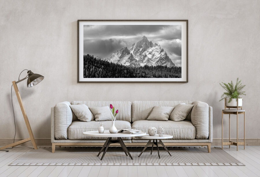 Framed black and white image of the Grand Tetons displayed above a couch in a modern home