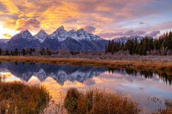 Photograph of the Grand Teton National Park at sunset with bright orange and blue colors.