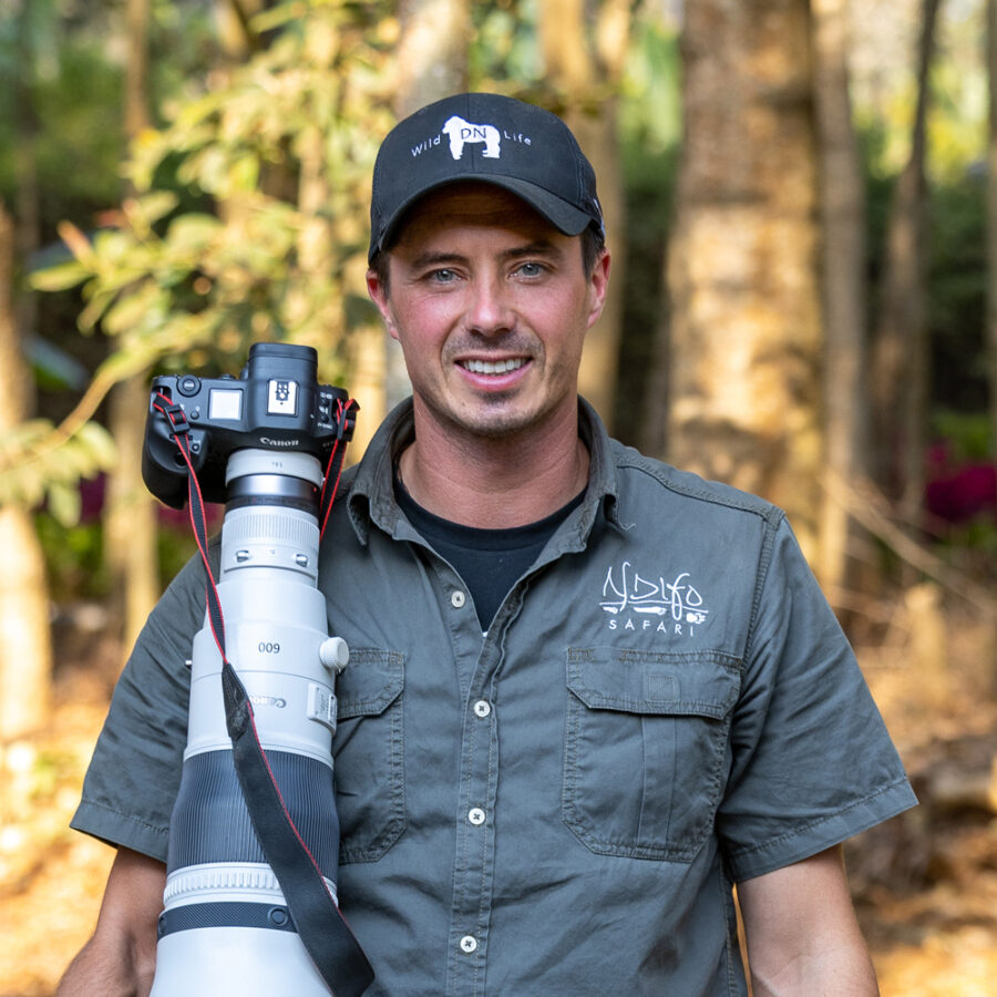 photo of photographer Derek Nielsen holding a 600mm lens on safari sending a strong message about his personal brand