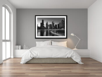 Large black and white framed print of chicago displayed in the bedroom of a luxury home